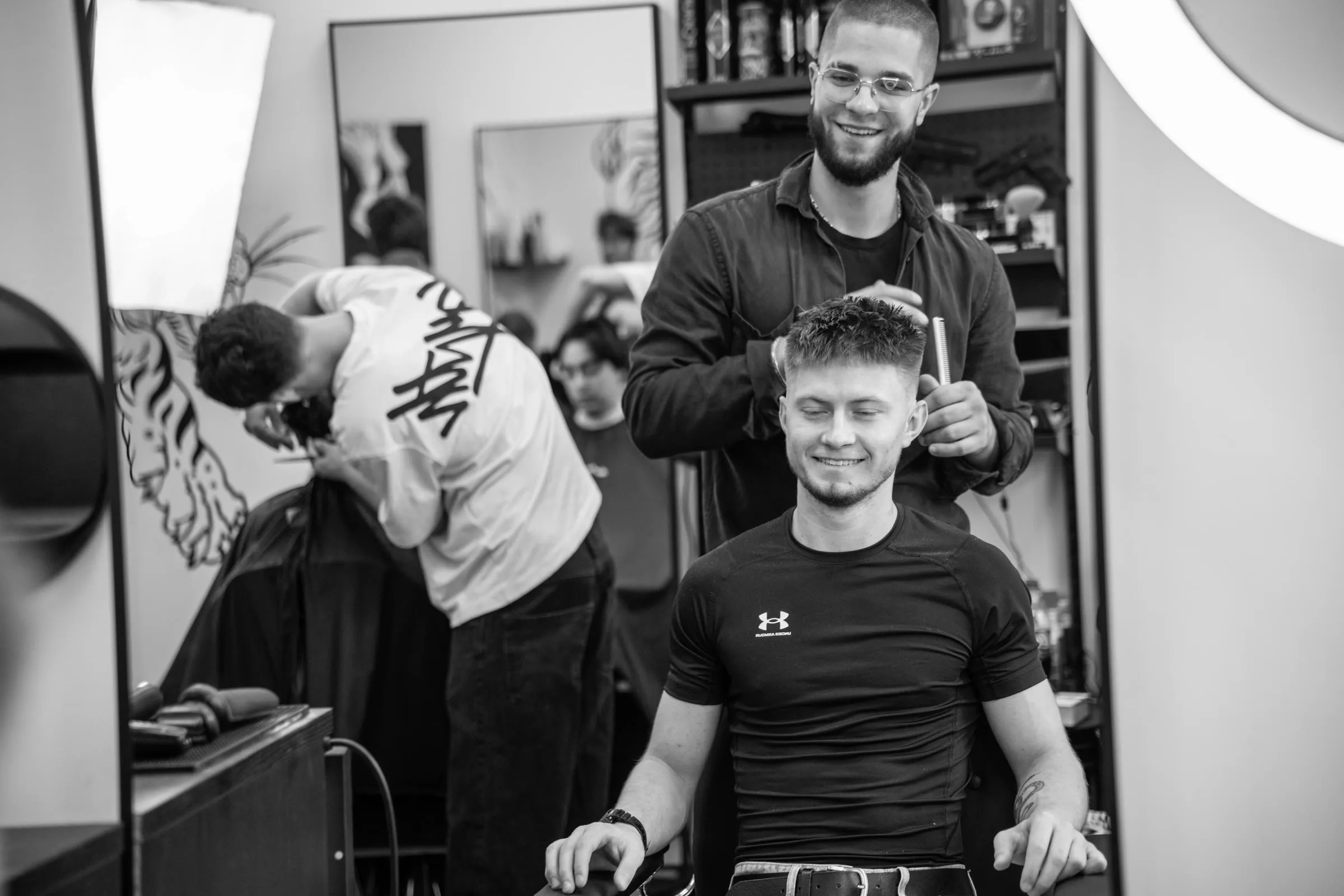 Barber i zadowolony klient przy lustrze